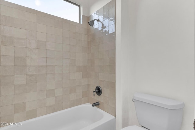 bathroom featuring toilet and tiled shower / bath