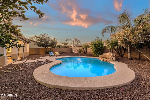 pool at dusk featuring a patio area