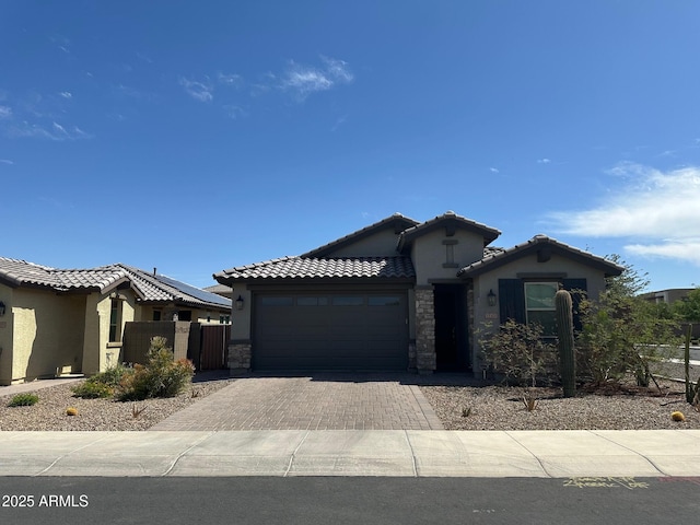 15301 W Moreland St, Goodyear, AZ 85338 - view of front of property with an attached garage, decorative driveway, stucco siding, and fence