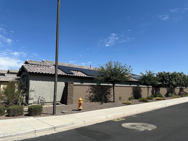 15301 W Moreland St, Goodyear, AZ 85338 - view of front of property featuring solar panels, a tiled roof, stucco siding, and fence