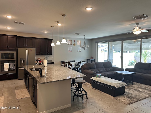 15301 W Moreland St, Goodyear, AZ 85338 - kitchen featuring a sink, oven, open floor plan, built in microwave, and stainless steel fridge with ice dispenser