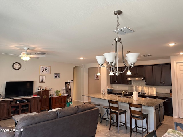 15301 W Moreland St, Goodyear, AZ 85338 - living room with light tile patterned floors, visible vents, ceiling fan with notable chandelier, and arched walkways