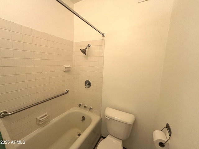 bathroom with tiled shower / bath combo and toilet