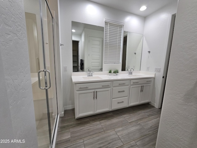 9137 W Sells Dr, Phoenix, AZ 85037 - full bathroom with a textured wall, double vanity, a stall shower, and baseboards