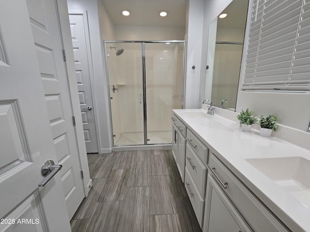 9137 W Sells Dr, Phoenix, AZ 85037 - full bathroom featuring a shower stall, double vanity, recessed lighting, and wood finished floors