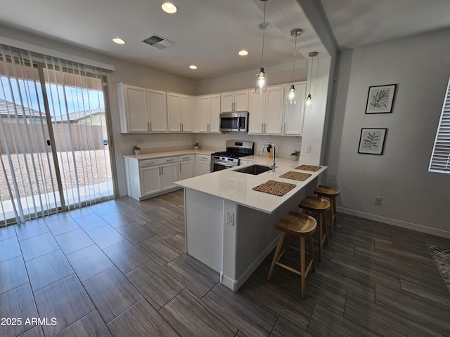 9137 W Sells Dr, Phoenix, AZ 85037 - kitchen featuring appliances with stainless steel finishes, a peninsula, light countertops, a sink, and recessed lighting