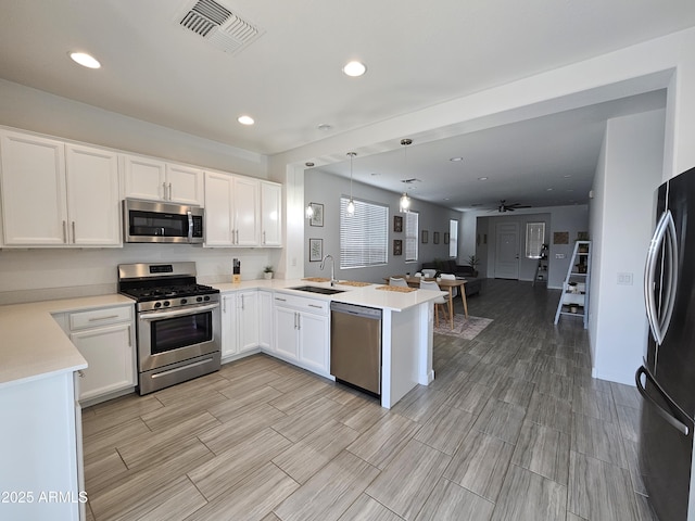 9137 W Sells Dr, Phoenix, AZ 85037 - kitchen with appliances with stainless steel finishes, a peninsula, a sink, light countertops, and open floor plan