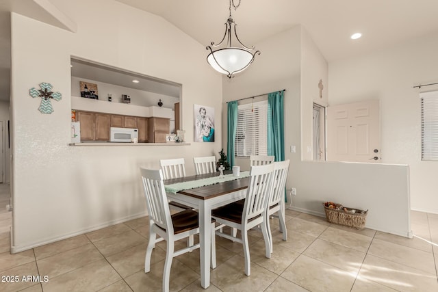 tiled dining room with lofted ceiling