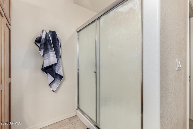 bathroom with tile patterned floors and a shower with shower door