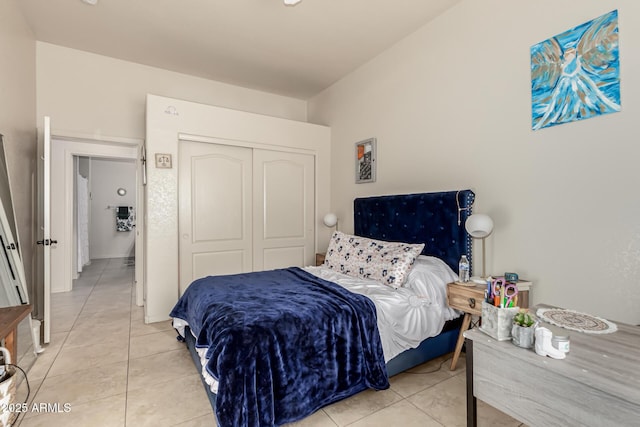 bedroom with light tile patterned floors and a closet