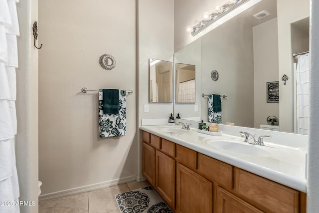 bathroom featuring tile patterned flooring, vanity, and toilet