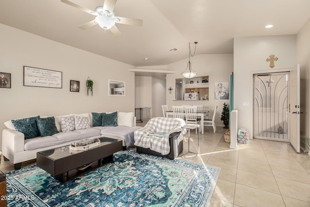 living room featuring ceiling fan, light tile patterned floors, and vaulted ceiling