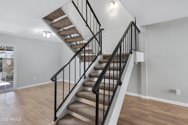 staircase with hardwood / wood-style floors