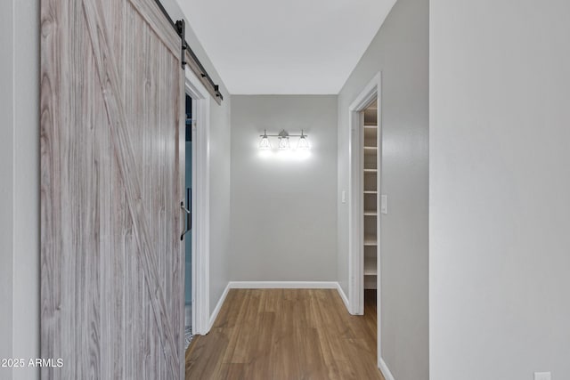 hallway with light hardwood / wood-style floors and a barn door