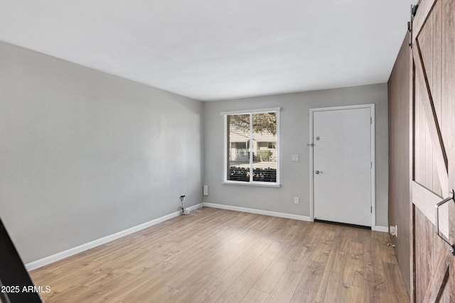 interior space with light hardwood / wood-style floors and a barn door