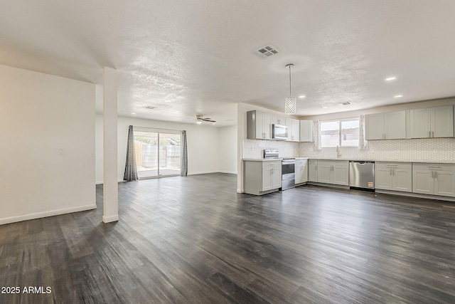 3017 N 46th Dr, Phoenix, AZ 85031 - kitchen featuring appliances with stainless steel finishes, healthy amount of natural light, open floor plan, dark wood finished floors, and a textured ceiling