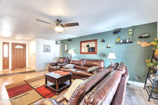 living room featuring ceiling fan and a textured ceiling