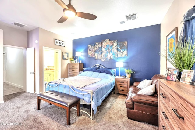 bedroom with ensuite bath, light colored carpet, and ceiling fan