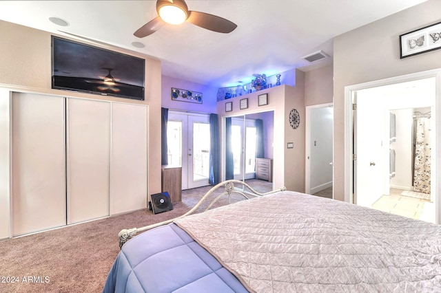 carpeted bedroom with french doors, ceiling fan, and ensuite bathroom