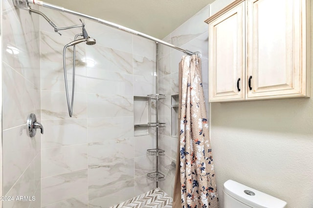 bathroom featuring curtained shower and toilet