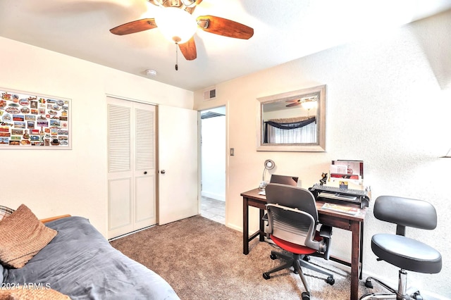 carpeted office space featuring ceiling fan