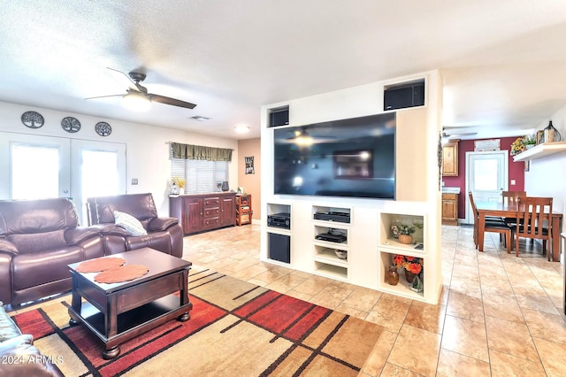 living room featuring french doors, ceiling fan, a textured ceiling, and light tile patterned floors