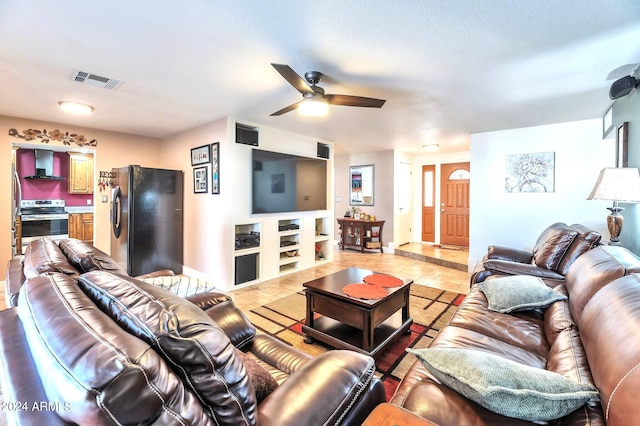 tiled living room featuring a textured ceiling and ceiling fan