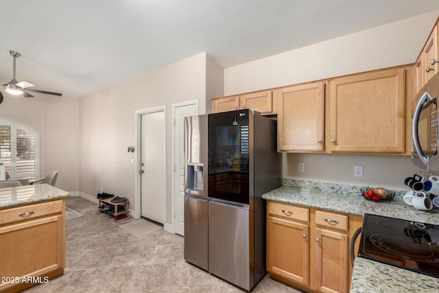 kitchen with appliances with stainless steel finishes, baseboards, light stone counters, and a ceiling fan