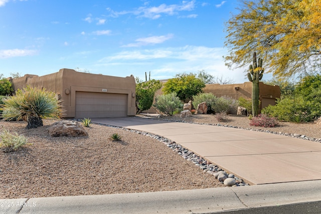 pueblo revival-style home featuring a garage