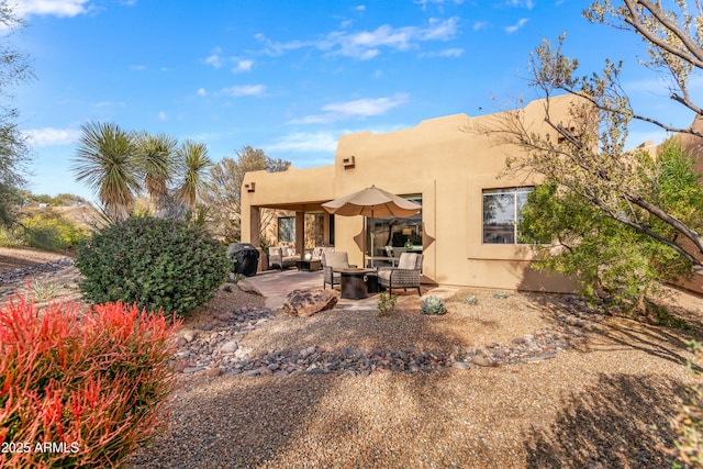 rear view of house with outdoor lounge area and a patio area