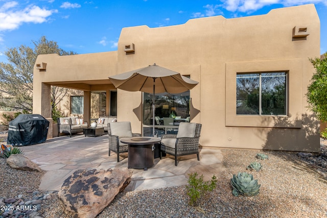 back of house featuring an outdoor living space with a fire pit and a patio area