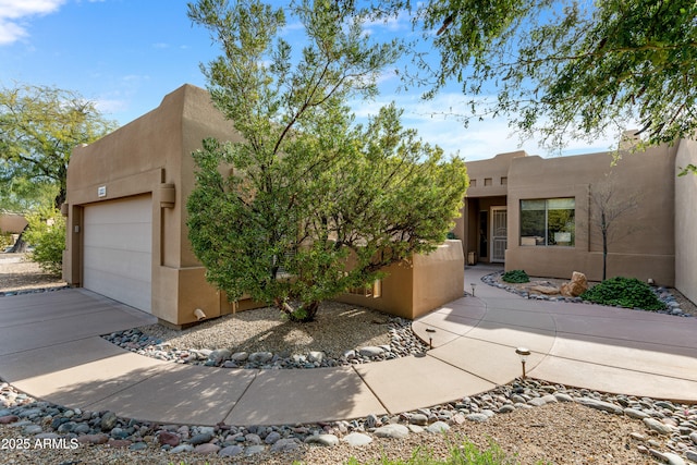 pueblo-style home featuring a garage