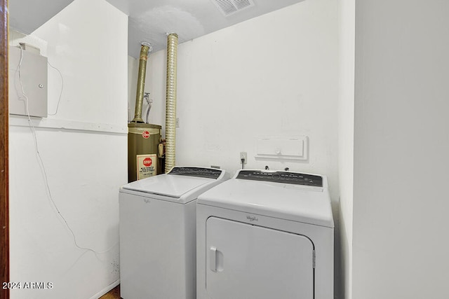 clothes washing area featuring water heater and independent washer and dryer