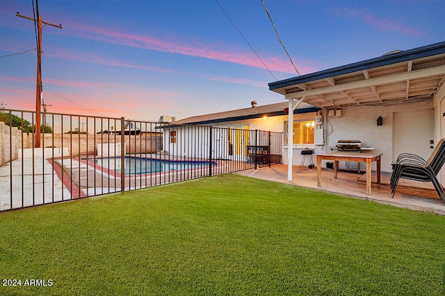 yard at dusk featuring a fenced in pool and a patio