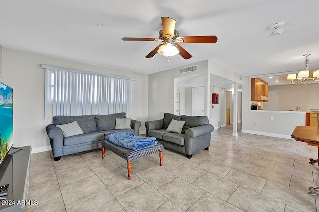 living room featuring ceiling fan with notable chandelier and light tile floors