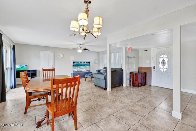 tiled dining space featuring ceiling fan with notable chandelier