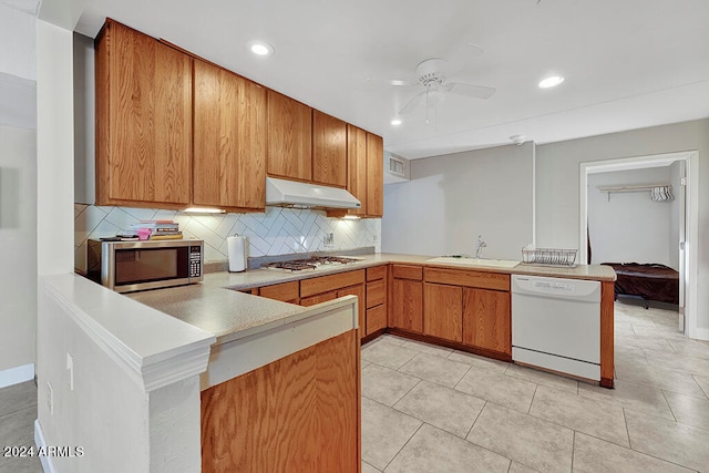 kitchen with ceiling fan, kitchen peninsula, backsplash, and stainless steel appliances