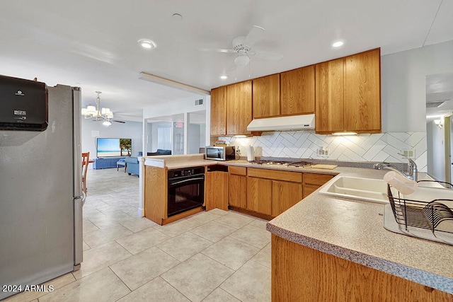 kitchen featuring kitchen peninsula, stainless steel appliances, ceiling fan with notable chandelier, tasteful backsplash, and sink