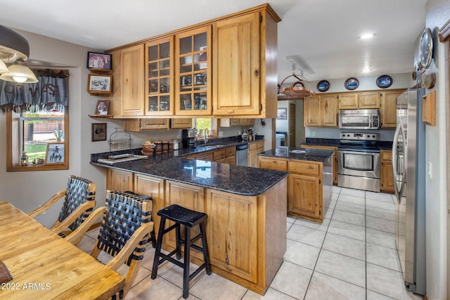 kitchen featuring kitchen peninsula, a kitchen island, sink, and stainless steel appliances