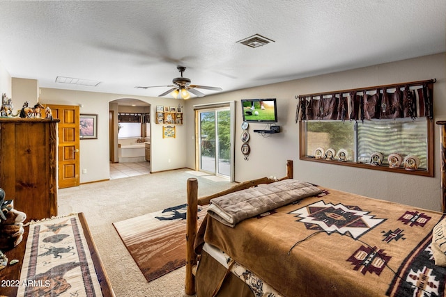 bedroom featuring ensuite bathroom, a textured ceiling, light carpet, access to outside, and ceiling fan