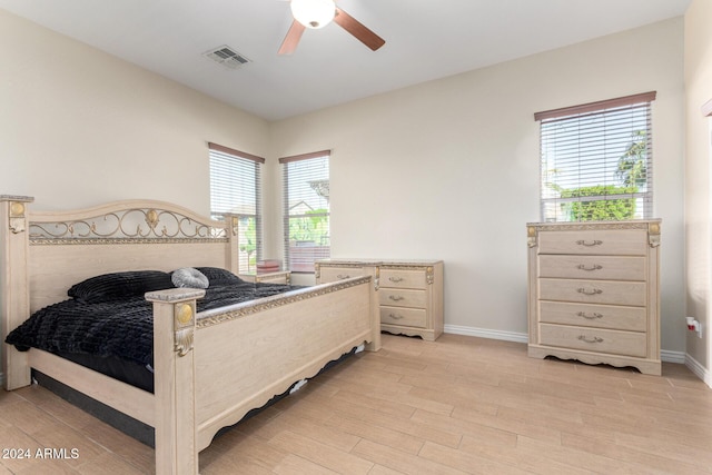 bedroom featuring multiple windows, ceiling fan, and light hardwood / wood-style flooring