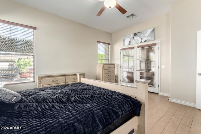 bedroom with light hardwood / wood-style floors, multiple windows, and ceiling fan