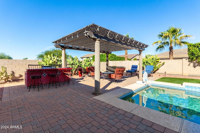 view of swimming pool featuring a pergola, an outdoor bar, and a patio