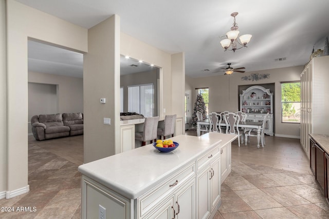 kitchen featuring pendant lighting, light hardwood / wood-style floors, a kitchen island, and a healthy amount of sunlight