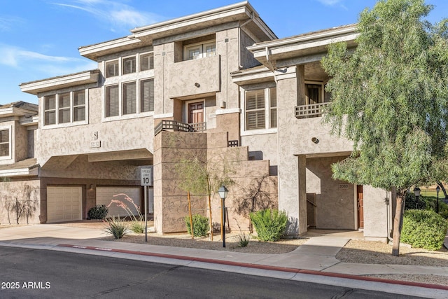 15221 N Clubgate Dr Unit 2059, Scottsdale, AZ 85254 - view of front of property featuring an attached garage, a balcony, stucco siding, and driveway