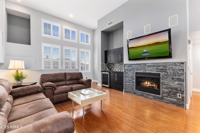 15221 N Clubgate Dr Unit 2059, Scottsdale, AZ 85254 - living room featuring beverage cooler, wood finished floors, a high ceiling, recessed lighting, and baseboards