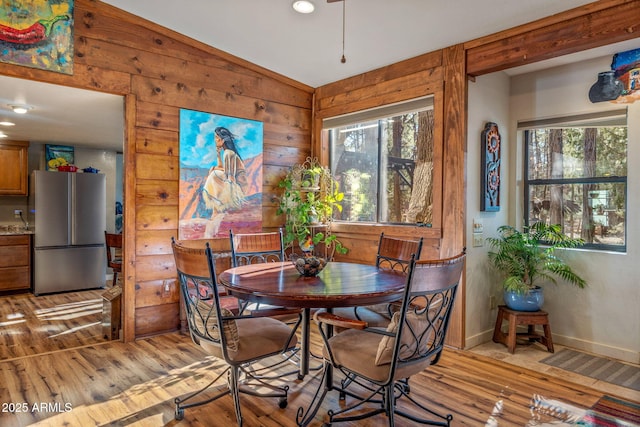 dining area with light wood-type flooring, vaulted ceiling, and a wealth of natural light