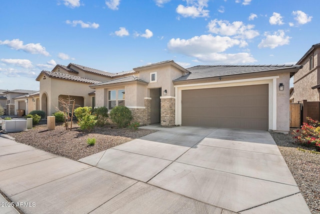 view of front of property featuring a tiled roof, concrete driveway, stucco siding, a garage, and stone siding