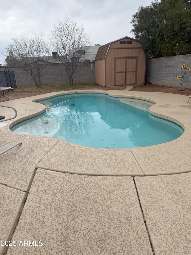 view of swimming pool with an outbuilding, a patio area, a fenced backyard, and a storage shed