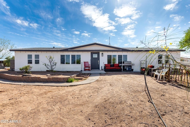 back of property featuring an outdoor living space and a patio area